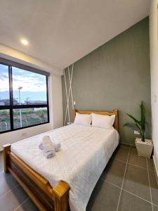 a bedroom with a large bed with a large window at CASA Y APARTAMENTOS PRIVADOS 2 y 3 habitaciones, PISCINA, JACUZZY, SAUNA cerca Aeropuerto, parque Del Cafe By Molca Xperiences in Armenia