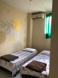 two beds sitting next to each other in a room at Pousada Trilha do Pelo in Salvador