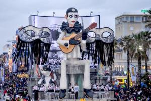 a statue of a woman with a guitar and a cat at Hotel Ely in Viareggio