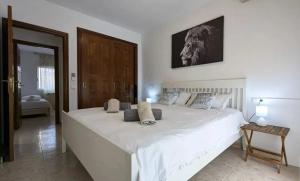 una camera da letto con un grande letto bianco con un quadro sul muro di Paraiso del Sol a Denia Altre 55 foto