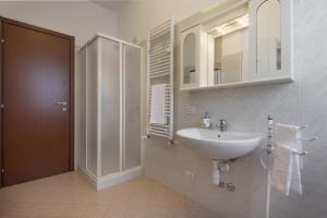 a white bathroom with a sink and a shower at San Macario House MXP Airport in Samarate