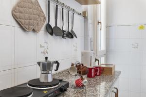 a kitchen counter with a coffee maker and utensils on the wall at San Macario House MXP Airport in Samarate +9 photos