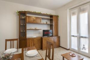 a living room with a dining table and a tv at San Macario House MXP Airport in Samarate