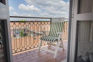 a green and white chair sitting on a balcony at San Macario House MXP Airport in Samarate
