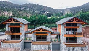 two houses on a hill with mountains in the background at Monte Verde Resort Kalavrita in Kalavrita