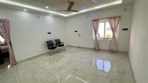 a living room with two chairs and a ceiling fan at Bhoomi mansion Homestay Apartment 12 in Bhubaneshwar