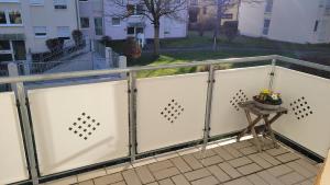 a fence with a table on a balcony at Mia Casa in Kehl am Rhein