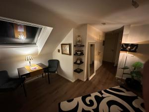 a living room with a desk and a television on the wall at Ferienwohnung Gütersloh in Gütersloh