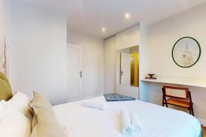 a bedroom with a white bed and a mirror at F2 Trocadero in Paris
