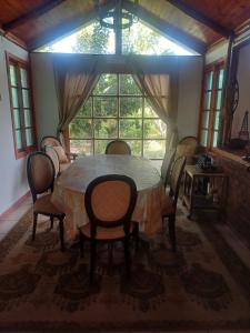 a dining room with a table and chairs and a window at PARCELA en MELIPILLA in Melipilla