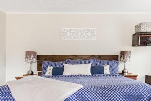 a bedroom with a blue and white bed with two lamps at Walk to Main Street HVL & Trail - Cozy Studio Retreat in Hendersonville