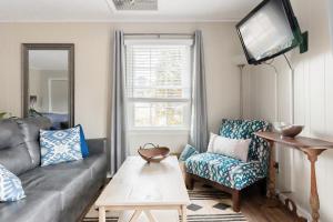 a living room with a couch and a tv at Walk to Main Street HVL & Trail - Cozy Studio Retreat in Hendersonville