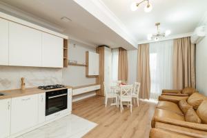 a kitchen and living room with a couch and a table at City Walk Apartment & MiRent in Chişinău
