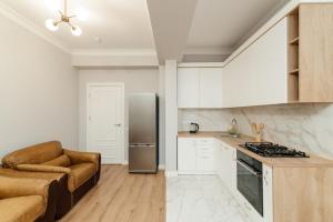 a kitchen with a couch and a refrigerator at City Walk Apartment & MiRent in Chişinău +28 photos