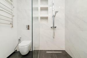a bathroom with a toilet and a glass shower at City Walk Apartment & MiRent in Chişinău
