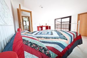 a bedroom with a bed with a quilt on it at Cherry House in Minturno