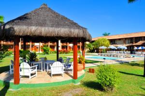 a gazebo with a table and chairs next to a pool at Sueds Cabralia in Santa Cruz Cabrália