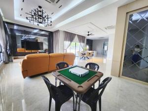 a living room with a table and chairs and a couch at Ipoh Botani Nardine luxury semi d 5br5bath19pax in Ipoh