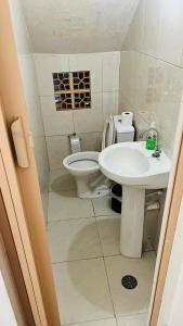 a bathroom with a toilet and a sink at Casa de Praia com Piscina no Litoral Norte SP in Caraguatatuba