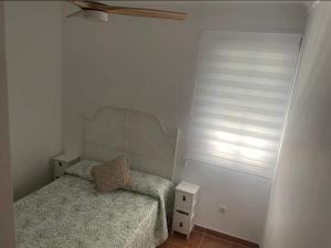 a small bedroom with a bed and a window at La Casa del Mar in Barbate
