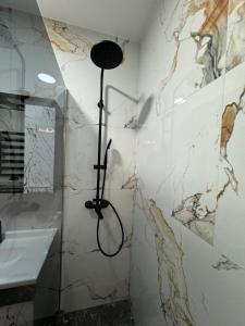 a shower in a bathroom with marble walls at Nice apartment in Chişinău +17 photos