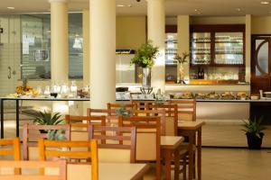 ein Restaurant mit Holztischen und -stühlen und einer Theke in der Unterkunft Hotel Caverá in Alegrete