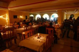 a restaurant with people sitting at tables in a room at Hôtel LES MIMOSAS TABARKA in Tabarka