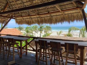 a table and chairs on a deck with the beach at Secret Spot by Palapita Beach House in Puerto Escondido