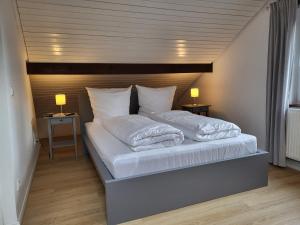a bed with white sheets and pillows in a room at Klaus Huus in Böhl