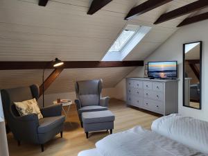 a bedroom with two chairs and a tv and a bed at Klaus Huus in Böhl