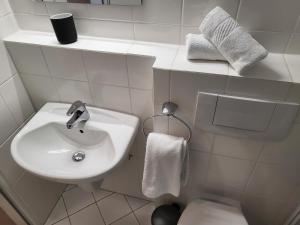 a white bathroom with a sink and a toilet at Klaus Huus in Böhl +13 photos
