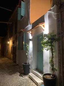 a building with two potted plants in front of a door at Old Town Retreat in Rhodes Town