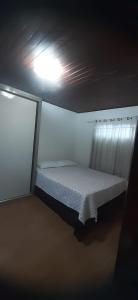 a bed in a room with a light on the ceiling at Lunar in Palhoça