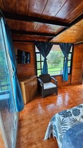 a bedroom with a bed and a chair in a room at Hospedaje Rural Sicaru in Pacho