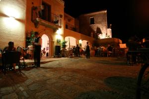 a group of people standing in a courtyard at night at Resort Borgo San Rocco in Savoca
