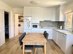 a kitchen with a wooden table and chairs in a room at Mirador de la Montaña Mágica in El Acebo de San Miguel
