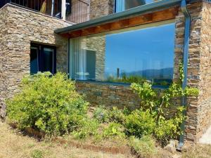 a brick building with a large window on the side of it at Mirador de la Montaña Mágica in El Acebo de San Miguel