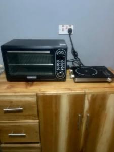 a microwave sitting on top of a wooden table at Shambani Homestay in Moshi +16 photos
