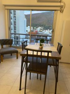 a table and chairs in a room with a large window at Alsina - Central Point Apartments in Salta