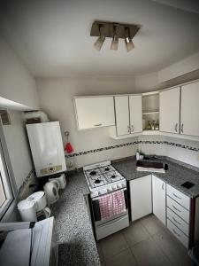Una cocina con gabinetes blancos y un horno de estufa. en Alsina - Central Point Apartments, en Salta