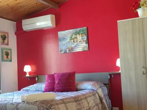 a bedroom with red walls and a bed with purple pillows at Oasi Iblea in Ragusa