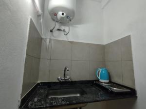 a bathroom sink with a soap dispenser on the wall at CARRERO Departamentos Apart in Chepes