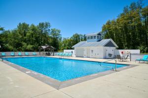 Una piscina con sillas y un edificio al fondo. en Dollybrook 7 Pet Friendly Community Pool Groups Welcome, en Fennville