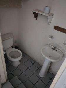 a bathroom with a toilet and a sink at Casa de tres habitaciones por infonavit constituyentes in Uruapan del Progreso