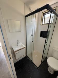 een badkamer met een douche, een toilet en een wastafel bij Box 07 a 950 mt do mar, ar- condicionado, TV smart, cozinha privativa in Itapema