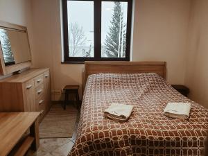 a bedroom with a bed with two towels on it at Go2Krynica - Zielony PitStop in Krynica Zdrój