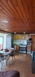 eine große Küche mit Tisch und Kühlschrank in der Unterkunft Casa familiar con hermosa vista al mar in Las Cruces