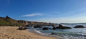 einen Strand mit Felsen und dem Meer an einem sonnigen Tag in der Unterkunft Casa familiar con hermosa vista al mar in Las Cruces