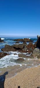 einen Strand mit Felsen und dem Meer an einem sonnigen Tag in der Unterkunft Casa familiar con hermosa vista al mar in Las Cruces