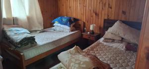 2 Einzelbetten in einem Zimmer mit Holzwänden in der Unterkunft Casa familiar con hermosa vista al mar in Las Cruces + 12 Fotos